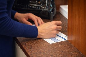 Seorang nasabah sedang mengisi formulir di salah satu bank.